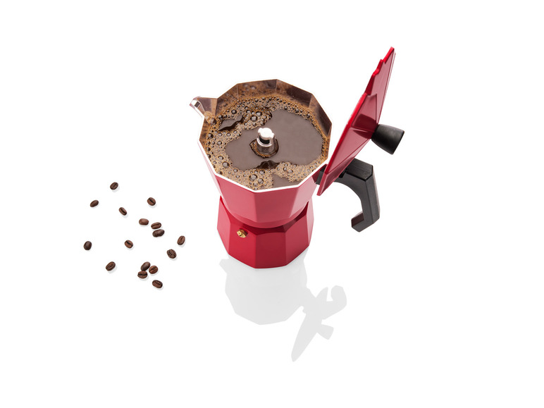 Eine rote Kaffeemaschine mit Kaffee und Kaffeebohnen.