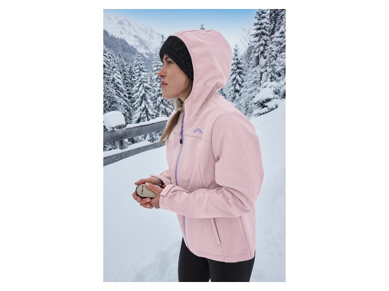 Frau in rosa CRIVIT Thermo-Softshelljacke und Mütze in verschneiter Berglandschaft.