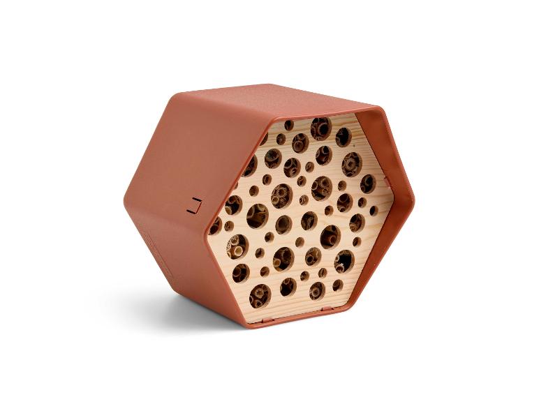Sechseckiges Insektenhotel in Terrakottafarbe mit Holztuben.