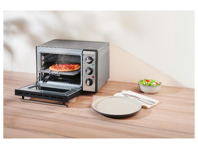 SilverCrest Mini-Ofen mit Pizza, daneben ein Teller und eine Salatschüssel.