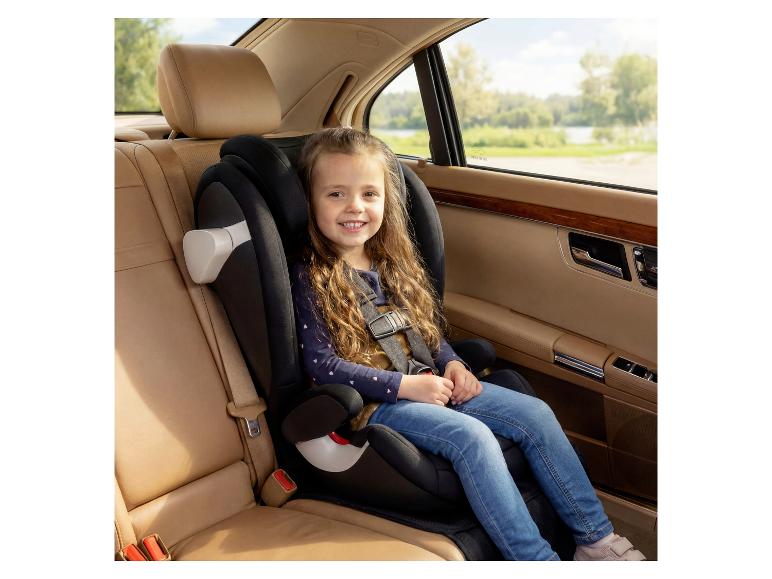 Lächelndes Kind im Kindersitz auf dem Rücksitz eines Autos