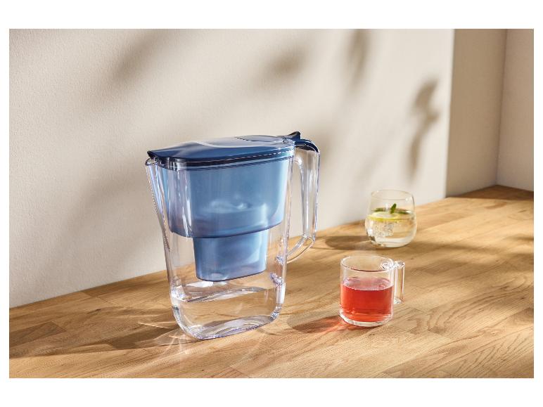 Wasserfilterkanne mit zwei Gläsern Getränken auf einer Holzoberfläche.