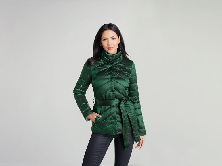 Eine Frau in einer grünen gesteppten Jacke mit Gürtel