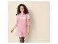 Frau in einem rosa Strickkleid mit weißen Schneeflockenmustern.
