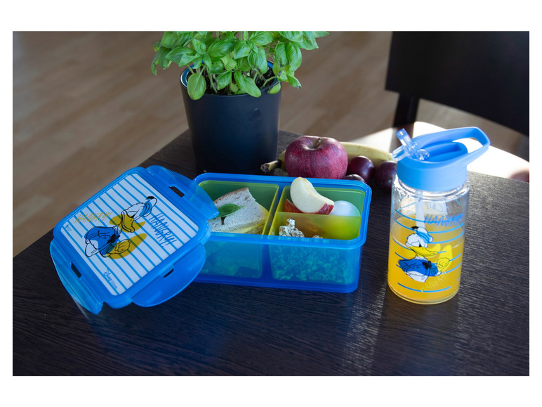 Eine blaue Lunchbox mit Donald Duck Motiv, eine Trinkflasche und ein Snack.