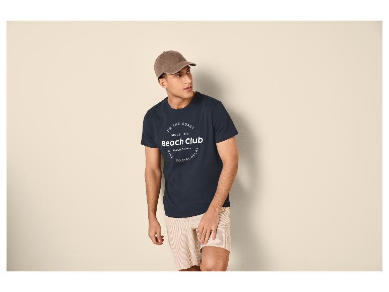 Mann in marineblauem T-Shirt mit „Beach Club“-Aufdruck und gestreiften Shorts