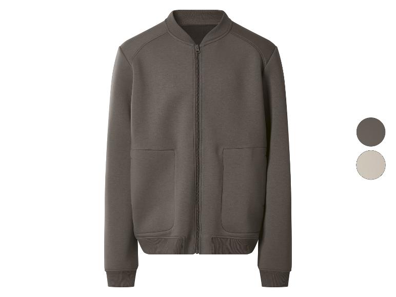 Dunkelbraune Bomberjacke mit Reißverschluss und Taschen, und eine beigefarbene Farbprobe.