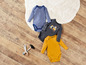 Drei Baby-Bodys: einer gestreift, einer mit Bagger-Druck und einer gelber.