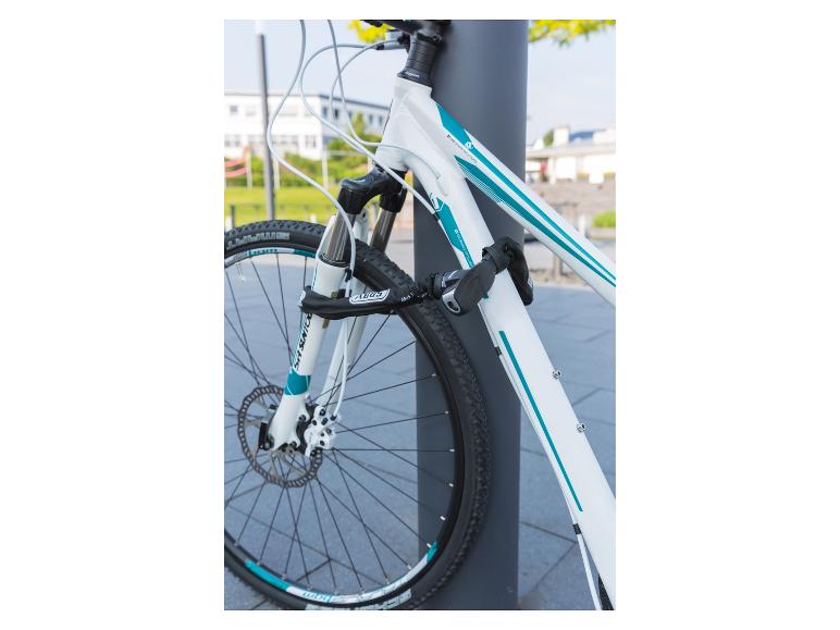 Weißes Fahrrad mit Abus Schloss an einem Pfosten befestigt.