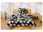 Ein Bett mit einem schwarzen Bettbezug mit weißen Blumen.