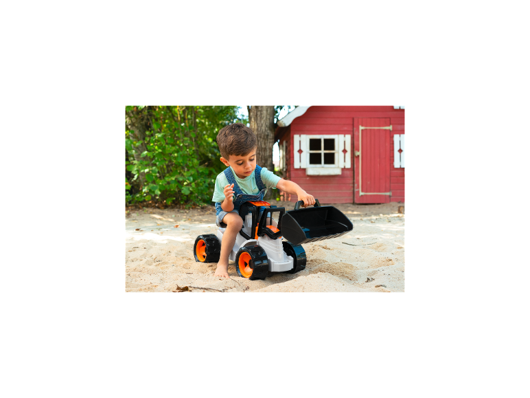 Ein kleiner Junge spielt im Sand mit einem LENA GIGA TRUCKS Aufsitz-Schaufellader.