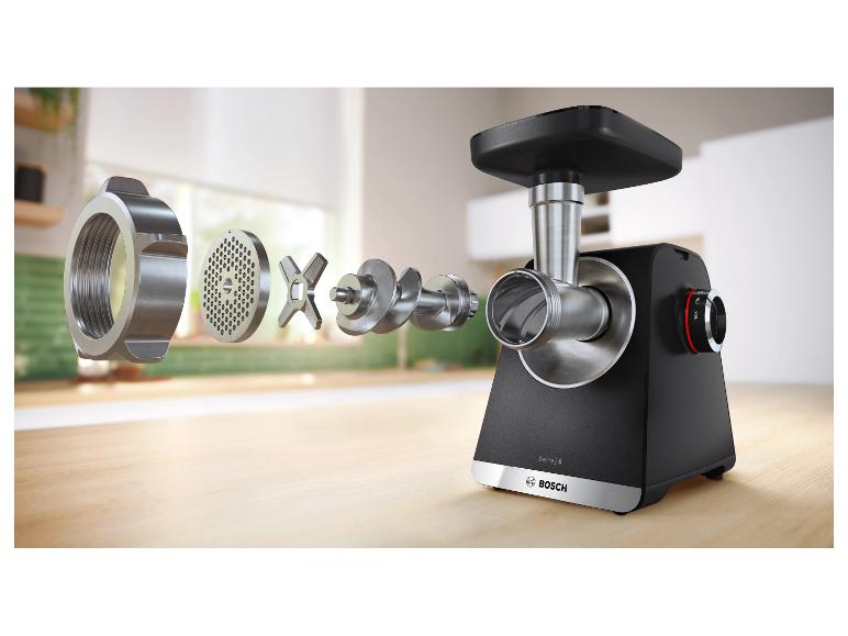 Explosionszeichnung eines Fleischwolfs mit seinen Komponenten auf einer Holzoberfläche.