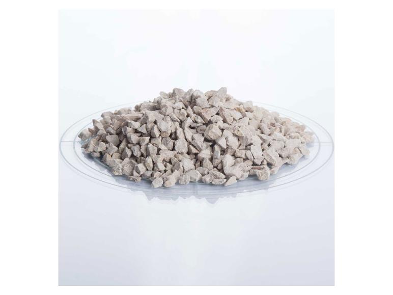 Ein Haufen hellgrauer Schotter auf einer transparenten Platte.