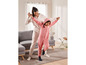 Eine Mutter und ihre Tochter in Pyjamas spielen im Wohnzimmer.