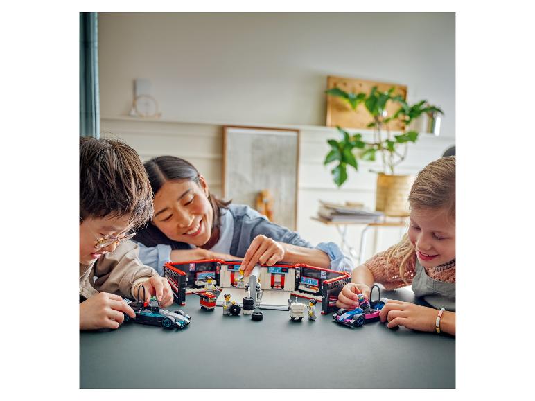 Drei Personen spielen mit LEGO Speed Champions Rennwagen und einer Garage.
