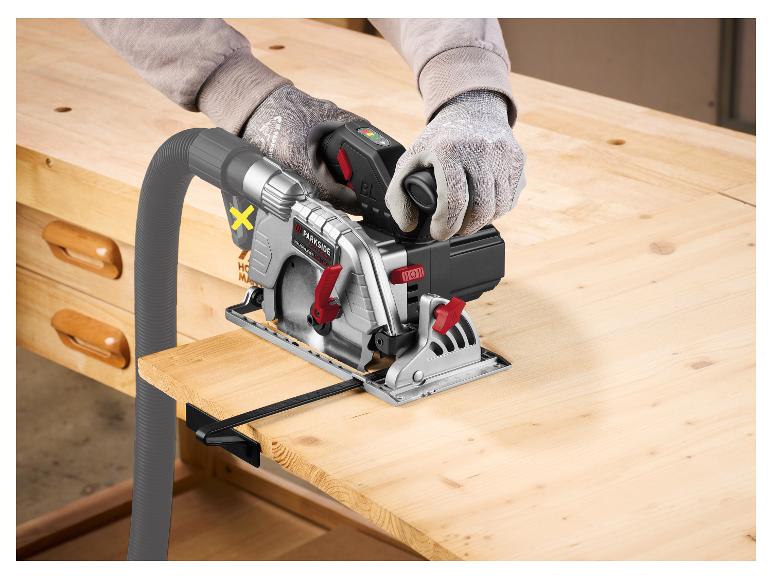 Kreissäge mit Absaugschläuchen schneidet Holz auf einer Werkbank.