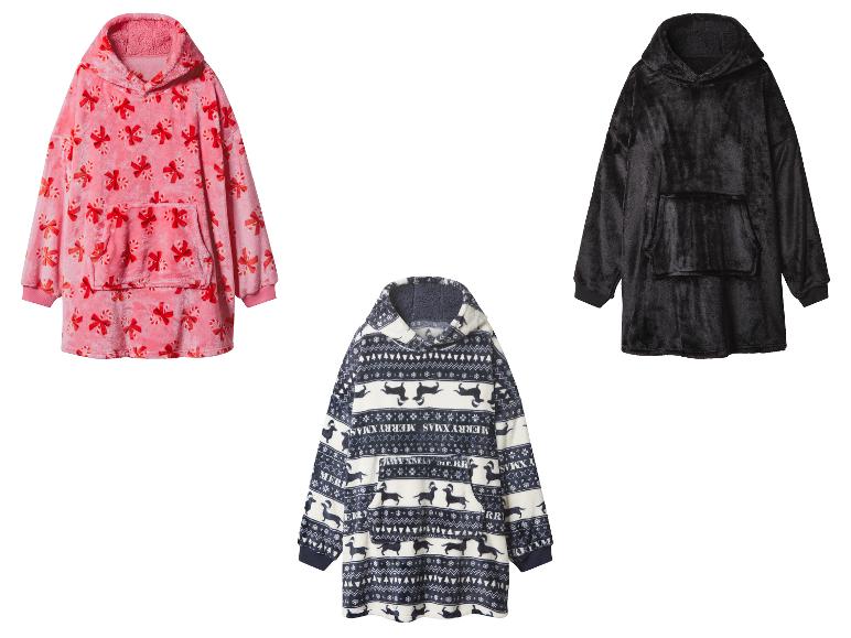 Drei übergroße Kapuzenpullover: rosa mit Zuckerstangen, schwarz und blau-weiß mit Weihnachtsmuster.