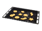 Schwarzes Backblech mit rohen Weihnachtsplätzchen in verschiedenen Formen.