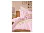 Schlafzimmer mit rosa gestreifter Bettwäsche, einem Holzkopfteil und gerahmter Blumenkunst an der Wand.