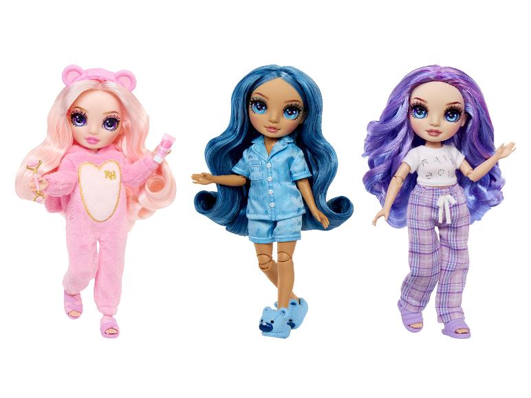 Drei Rainbow High Puppen in bunten Pyjamas, darunter ein rosa Overall und Hausschuhe.