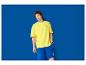 Mann in gelbem T-Shirt und blauen Shorts mit Lidl-Logo.