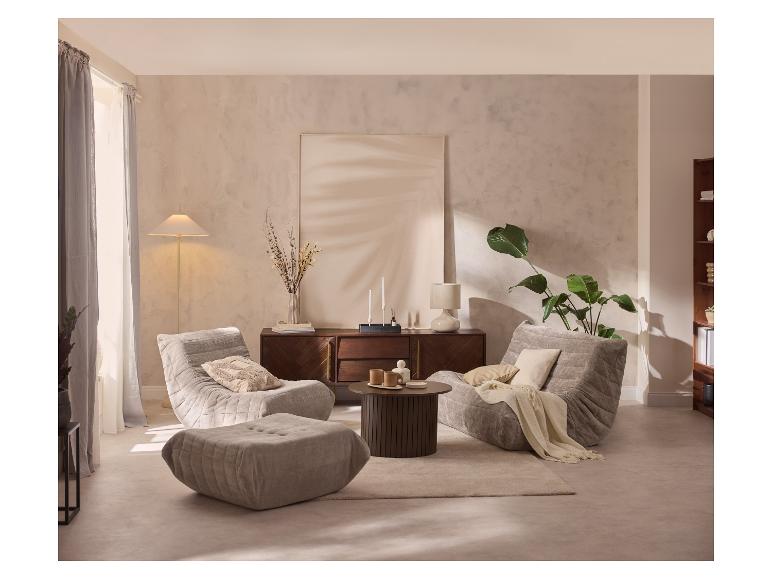 Wohnzimmer mit zwei grauen Sesseln, passendem Hocker, einem Couchtisch aus Holz und einem Sideboard.