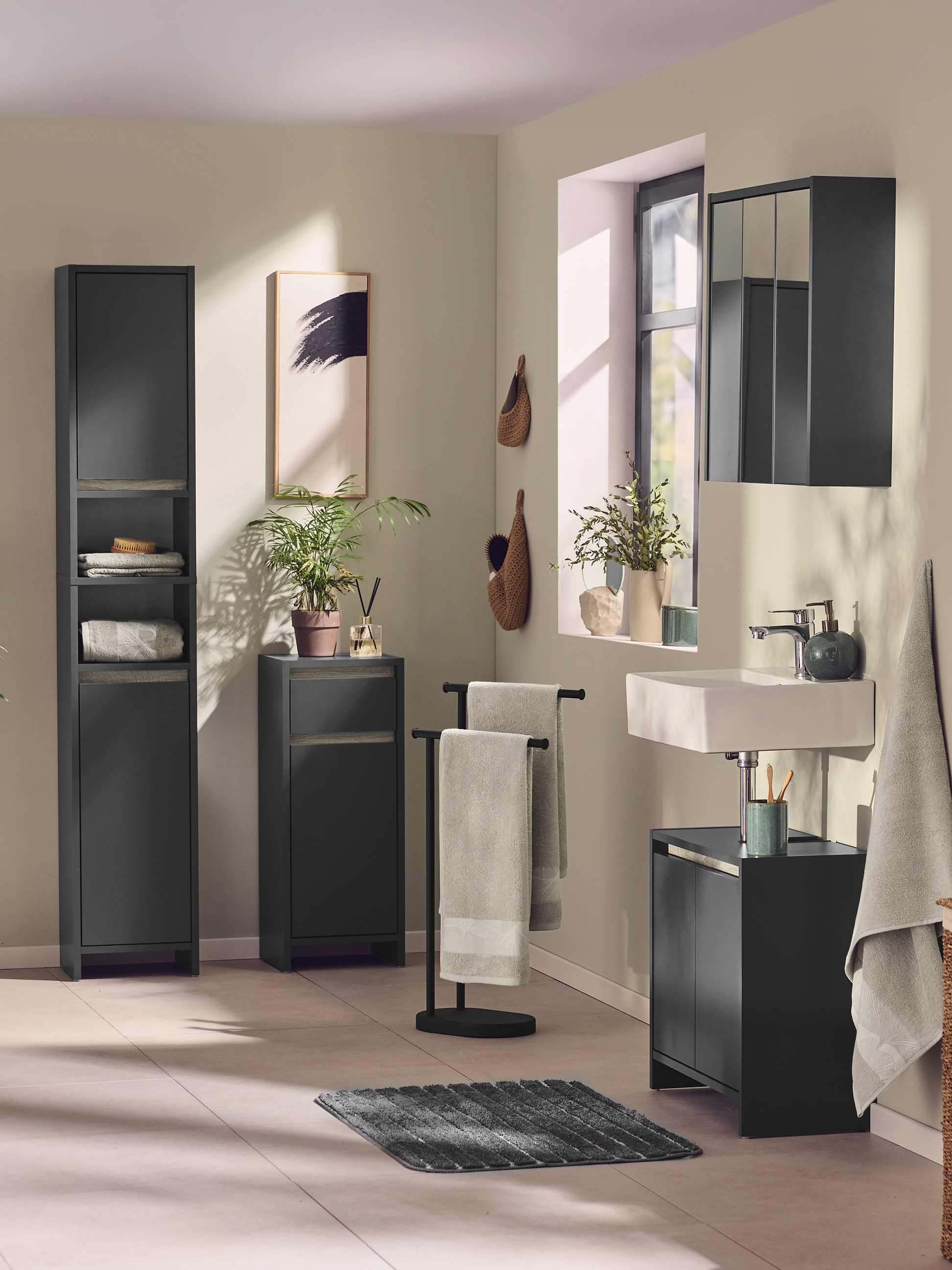 Modernes Badezimmer mit dunkelgrauen Aufbewahrungsmöbeln und passenden Accessoires.