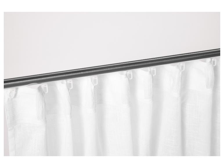 Weiße Vorhänge mit Quasten an einer dunklen Stange.