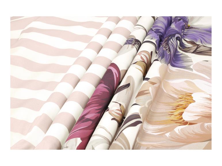 Gefaltete Stoffe mit Streifen, Blumen und Blättern in Lila-, Beige- und Rosatönen.