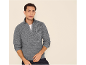 Mann in einem grauen Half-Zip-Pullover und dunklen Jeans, blickt direkt in die Kamera.