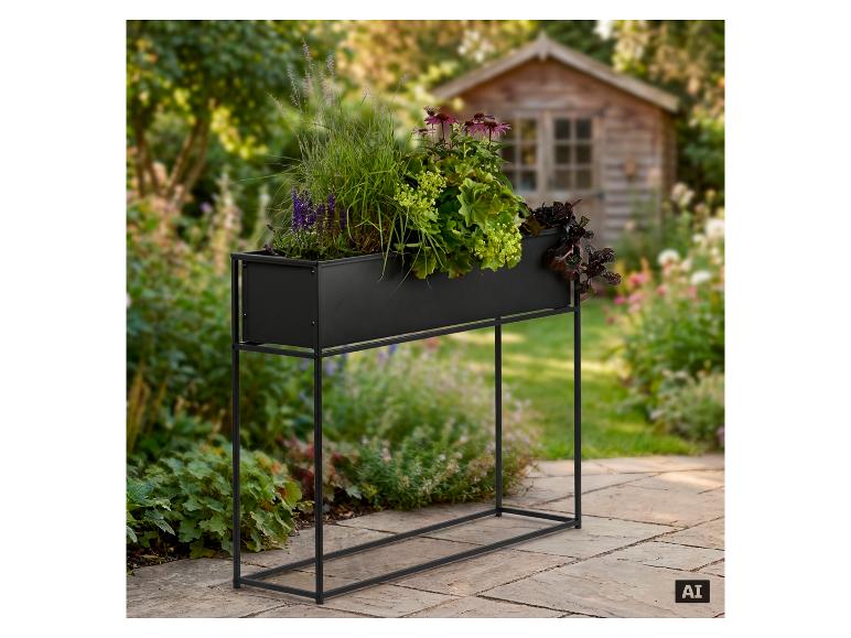 Schwarzer Metall-Pflanzkübel mit verschiedenen Pflanzen in einem Garten mit Schuppen im Hintergrund.