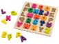 Holzpuzzle mit bunten Alphabetbuchstaben, einige außerhalb des Brettes.