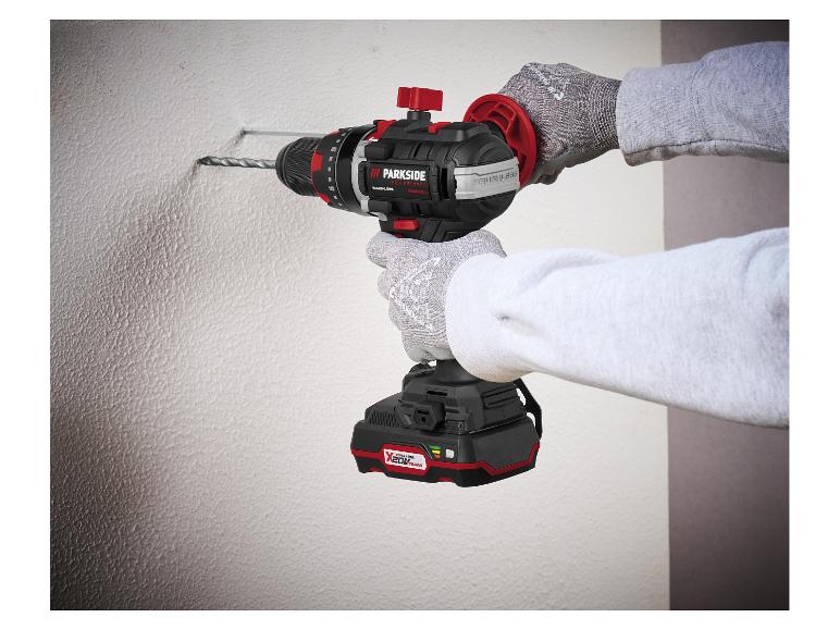 Person bohrt mit einem Akku-Bohrhammer in eine Wand.