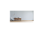 Grauer Sessel, Holzsideboard mit Dekorationen und Pendelleuchten in einem modernen Wohnzimmer.