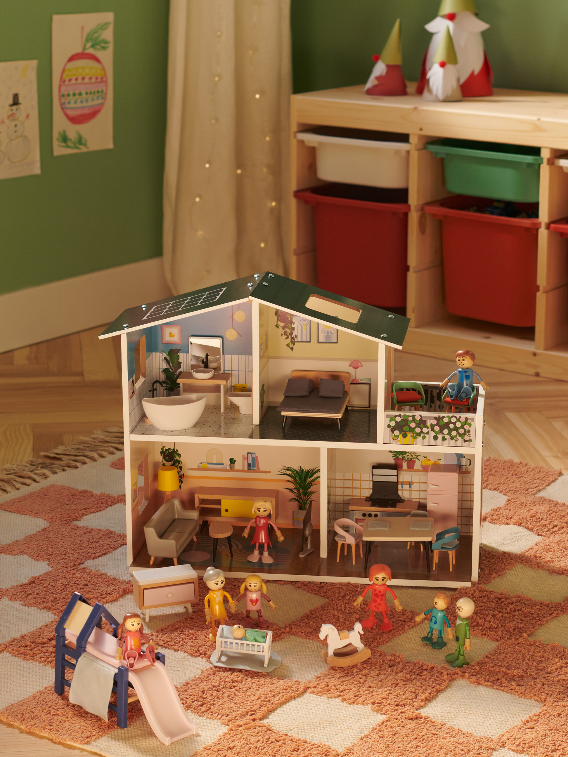 Holzpuppenhaus mit Figuren und Möbeln, umgeben von Teppich und Spielzeug.