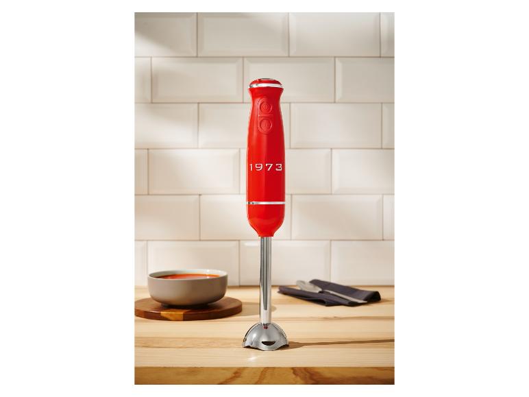 Ein roter KitchenAid 1973 Stabmixer auf einer Küchenarbeitsplatte.