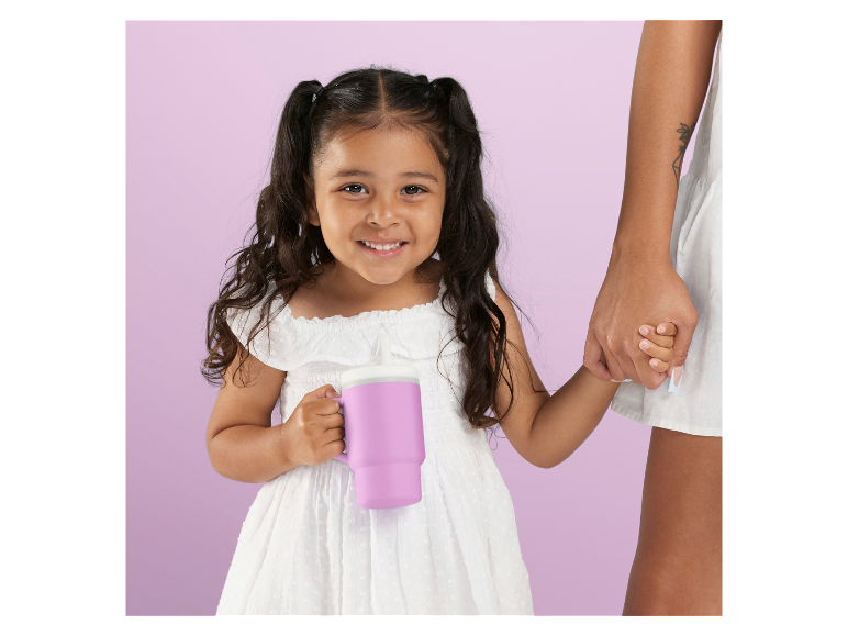 Mädchen mit lila Becher, lächelt und hält ein Erwachsenen an der Hand.