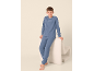 Junge in blauem Fleece-Pyjama mit dem Schriftzug WEEKEND, der an einem weißen Stuhl lehnt.