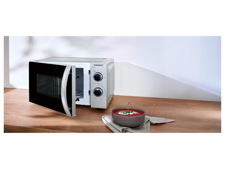 Silvercrest Mikrowelle mit offener Tür und eine Schale Suppe auf einem Holztisch.