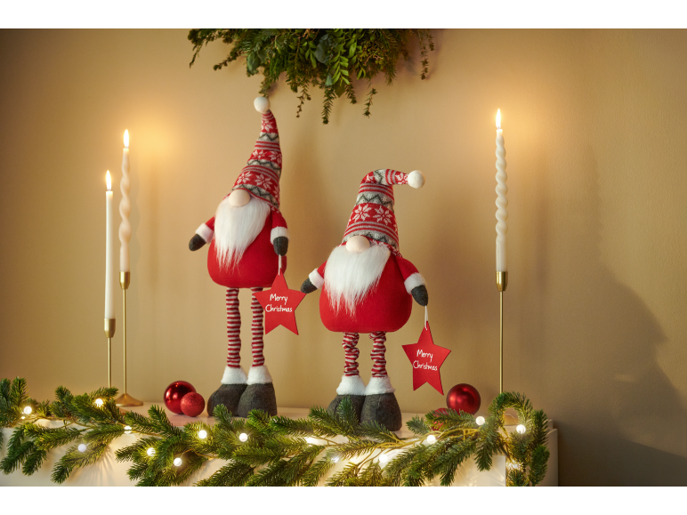 Zwei Weihnachtswichtel halten „Merry Christmas“-Sterne, mit Kerzen und Girlande.