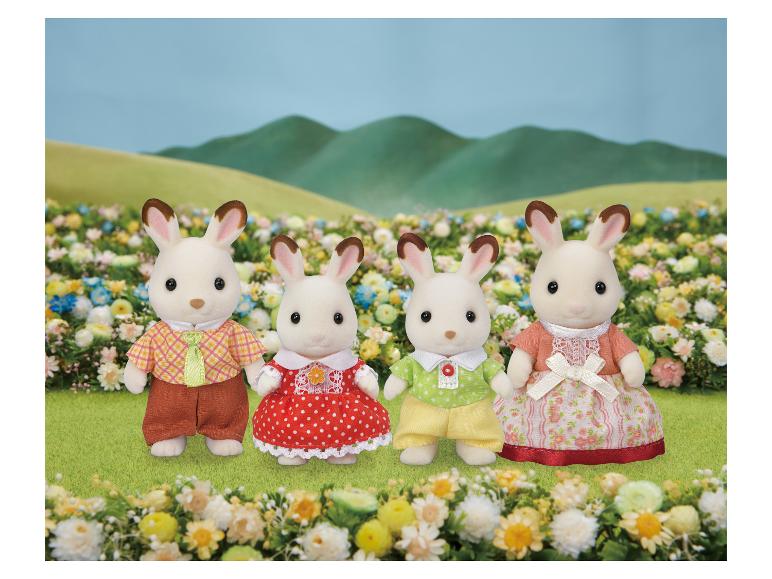 SYLVANIAN FAMILIES Sammelfigur Familie: Vier Hasenfiguren in bunter Kleidung auf einer Blumenwiese.