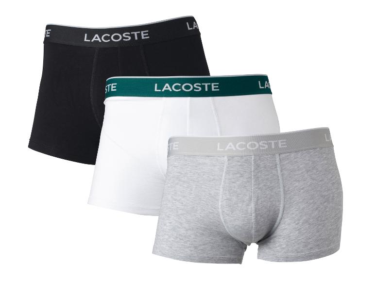 Drei Lacoste Boxershorts in Schwarz, Weiß und Grau.