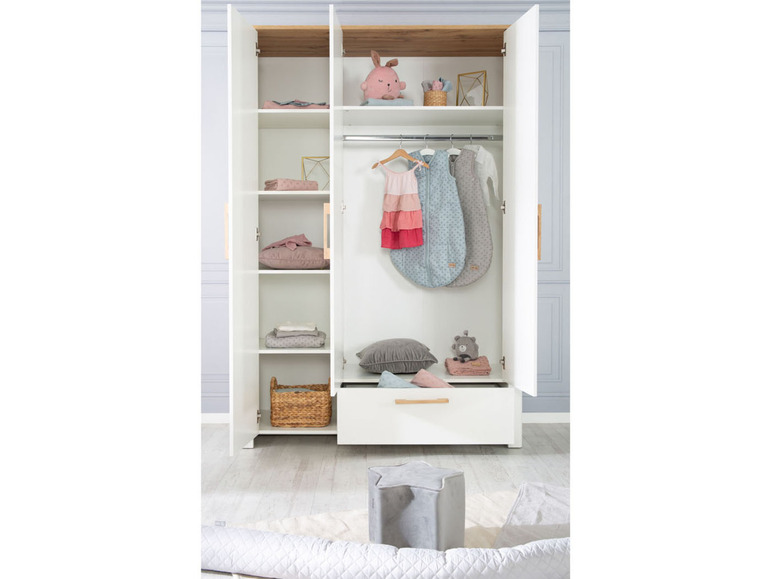 Ein weißer Kleiderschrank mit Schlafsäcken, Plüschtieren und einem Korb