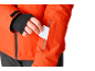 Mann steckt weiße Karte in die Tasche einer orangefarbenen Jacke.