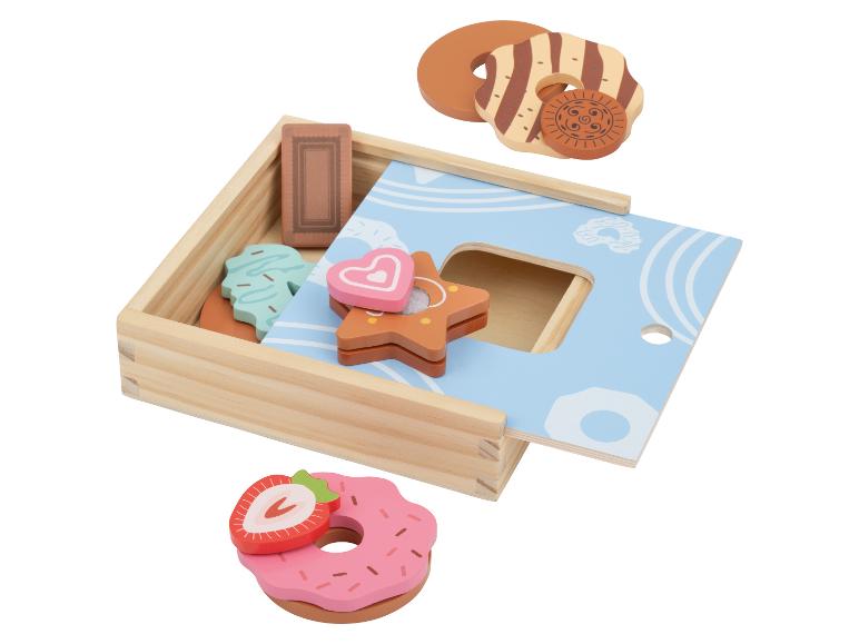Holzspielzeug mit Bäckereithema, darunter Donuts und Kekse, in einer Sortierbox.