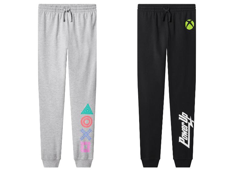 Zwei Kinder-Jogginghosen: grau mit PlayStation-Logo und schwarz mit Xbox-Logo und „Power Up“-Schriftzug.