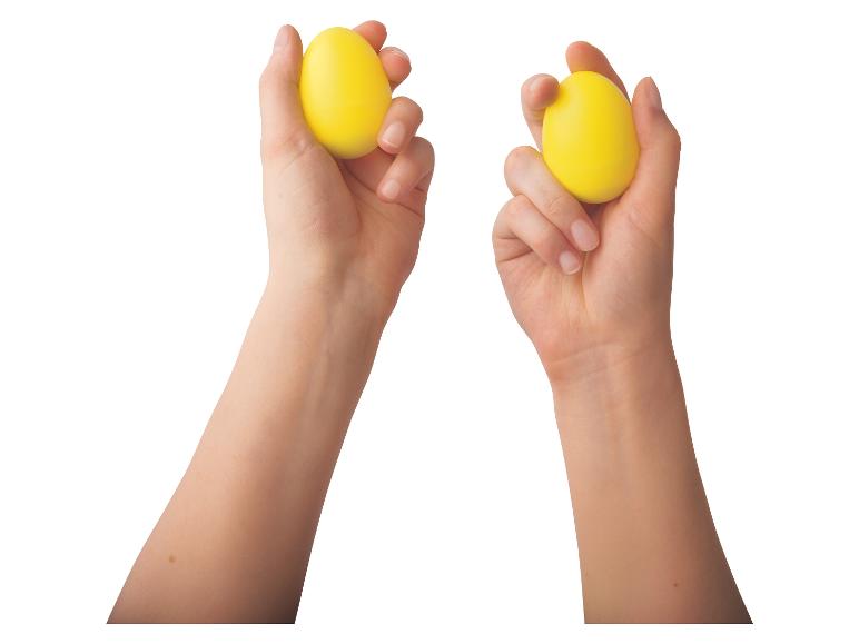 Zwei Hände halten gelbe Eier fest.