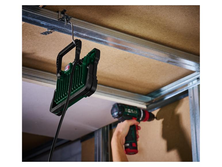 Hängende LED-Arbeitsleuchte und Akku-Bohrschrauber auf einer Baustelle.