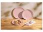 Pastellrosa Teller mit Fruchtcrepes und Kupferbesteck auf einem Holztisch.