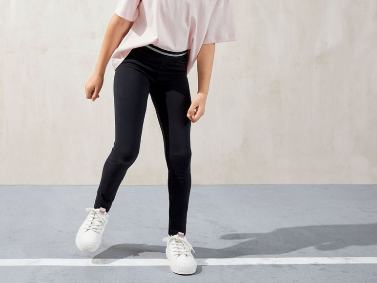 Schwarze Leggings und weiße Sneaker für Damen.